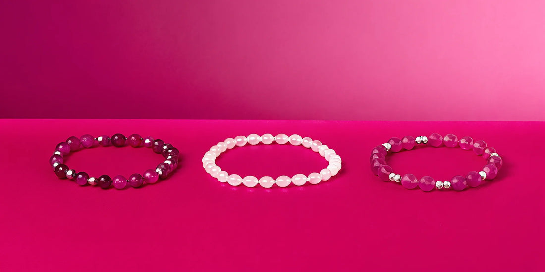 Healing crystal bracelets on a pink background.