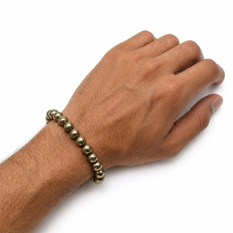 Brassy gold pyrite beaded bracelet worn on a wrist