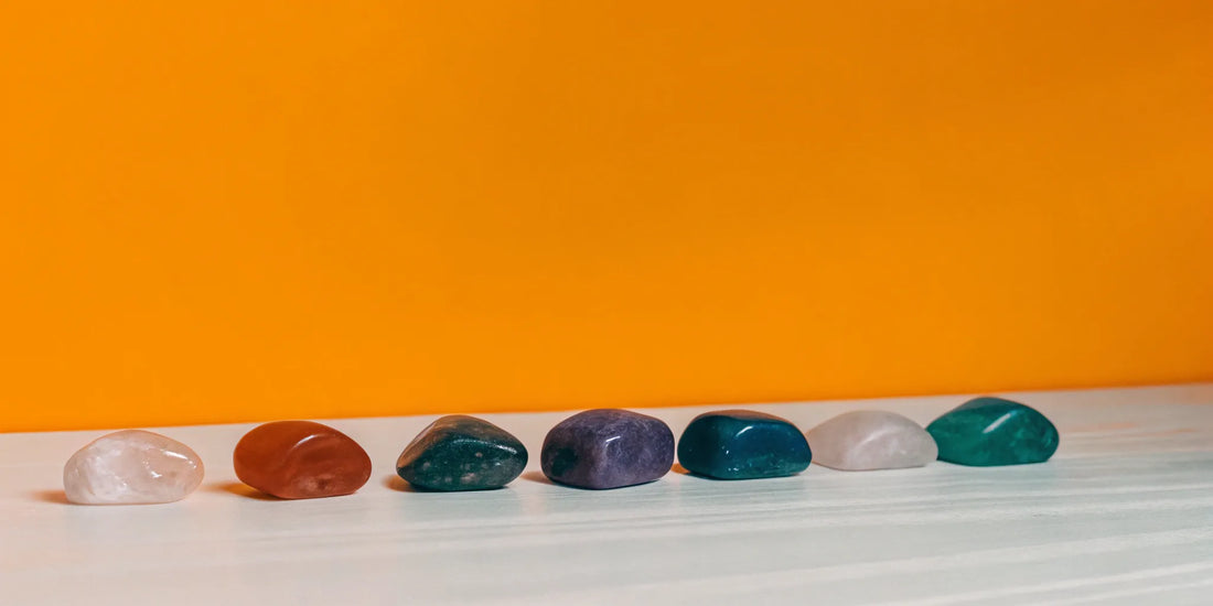 7 chakra crystals on a white surface.