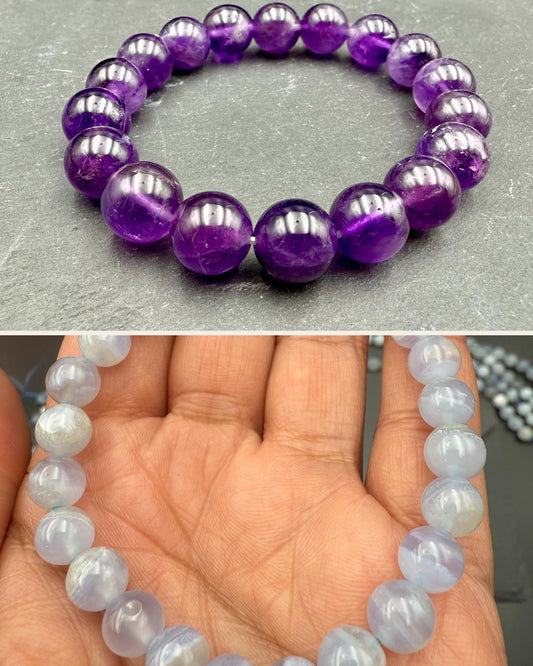 Amethyst bracelet on slate above a blue lace agate bracelet held in a palm