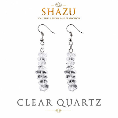 May include: A pair of drop earrings featuring silver-toned hooks and a vertical arrangement of clear, irregular-shaped quartz stones. The text SHAZU SOULFULLY FROM SAN FRANCISCO and CLEAR QUARTZ is visible at the top and bottom of the image.