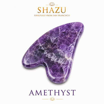 May include: A heart-shaped gua sha tool crafted from deep purple amethyst stone with visible crystalline textures and smooth, polished edges. The text SHAZU SOULFULLY FROM SAN FRANCISCO and AMETHYST appear in gold and purple lettering above and below the stone.