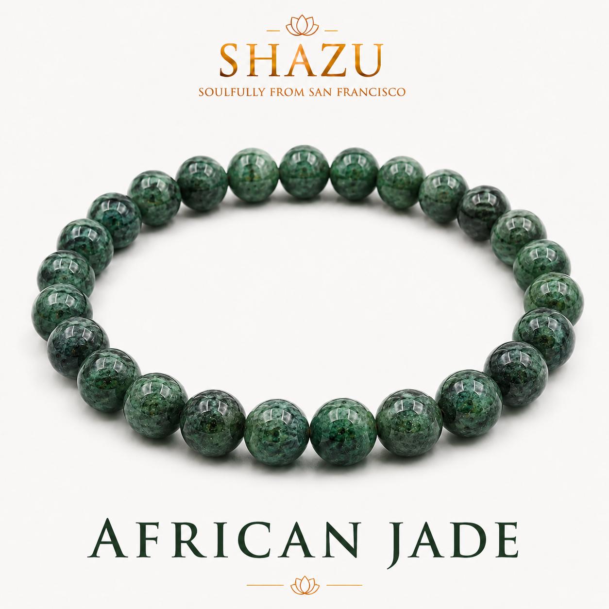 May include: A beaded bracelet made of round, polished African jade stones in shades of deep forest green with dark mottled patterns. The text SHAZU SOULFULLY FROM SAN FRANCISCO and AFRICAN JADE is printed above and below the bracelet.