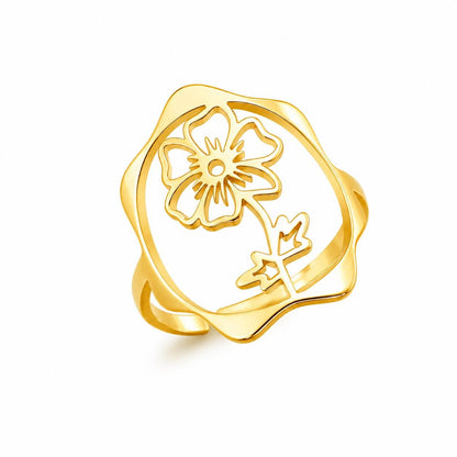 May include: A gold-toned ring featuring an openwork design with a central flower motif. The ring has a smooth, polished finish and a wavy, organic-shaped outer frame that surrounds the floral cutout, creating a continuous, singular piece.